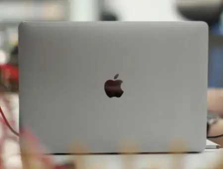 A data recovery engineer restores files on a MacBook in a specialized lab.